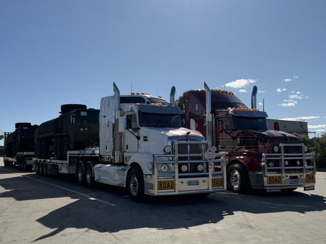 Road train carrying armoured vehicles